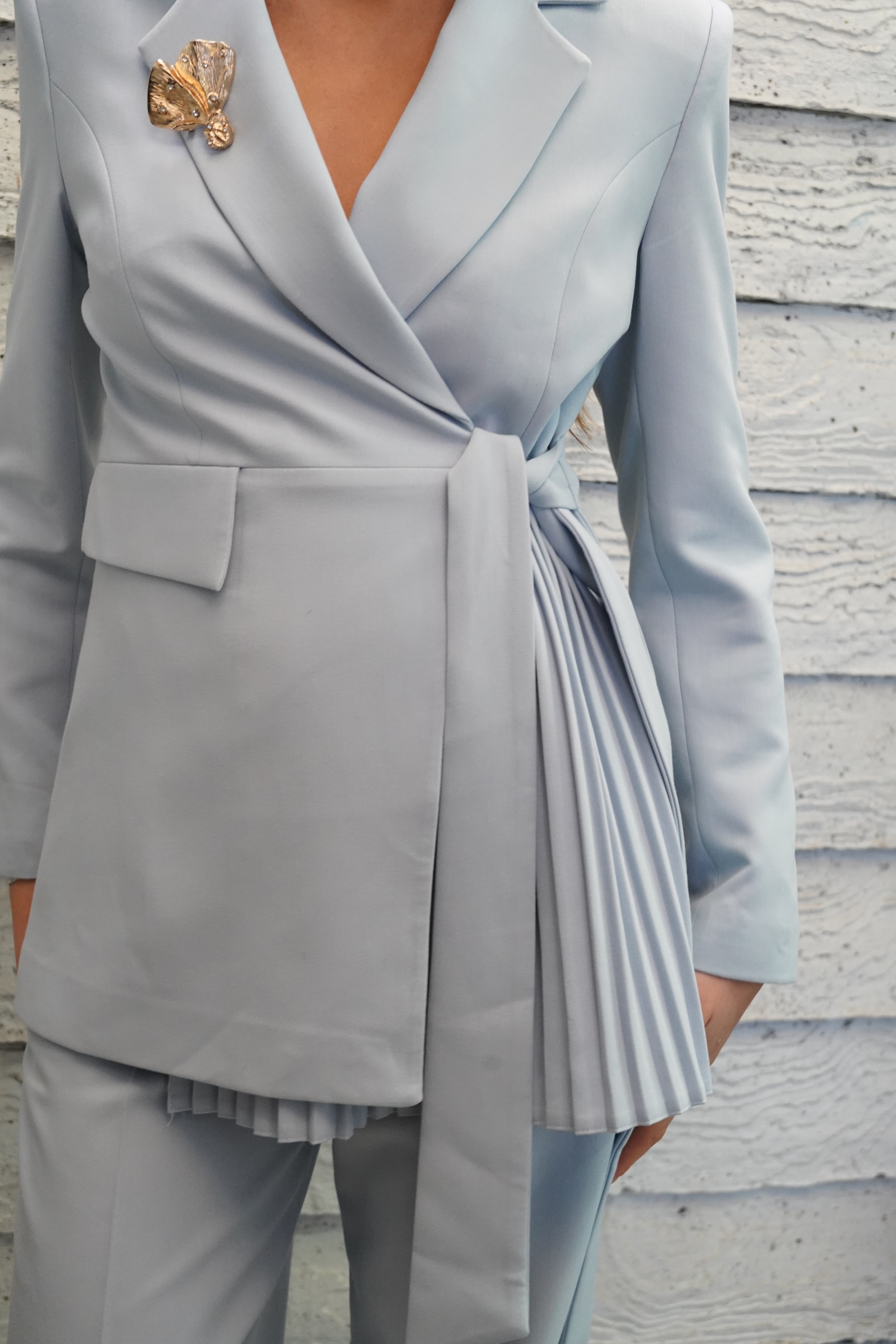 Conjunto traje con broche dorado detalle plisado y lazo celeste baby